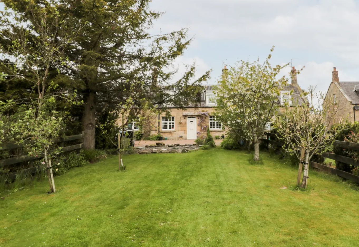 Charming small walled cottage garden with rustic wooden table and stunning countryside views